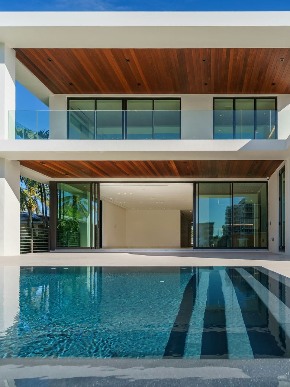 White contemporary villa with large aluminium sliding doors over a pool