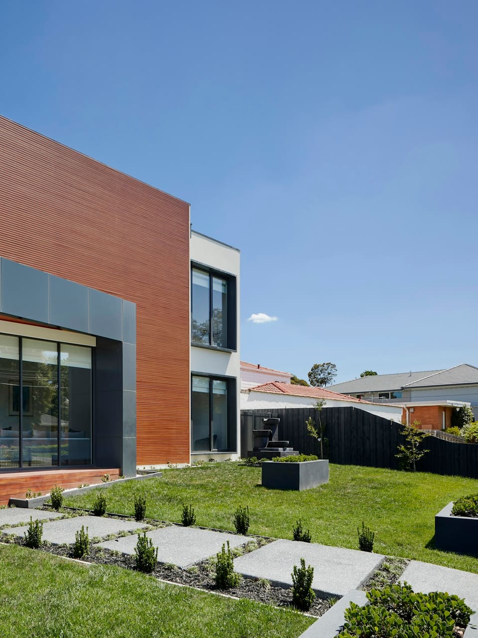 Modern family house with dark-framed windows and a timber-clad facade